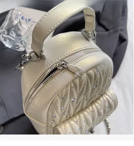 Detailed macro of cream quilted faux leather with rhinestone accents and silver zipper