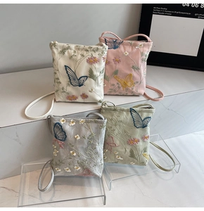 Detail of four embroidered crossbody bags in beige, pink, blue, and green floral patterns