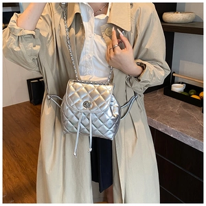 Close-up of a silver quilted mini backpack featuring metallic leather and a chain strap