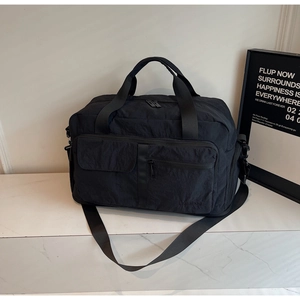Detail view of black travel bag with multi-pocket design and water-resistant fabric
