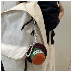 Detail of creative hat-shaped mini pouch with zipper and carabiner on a backpack