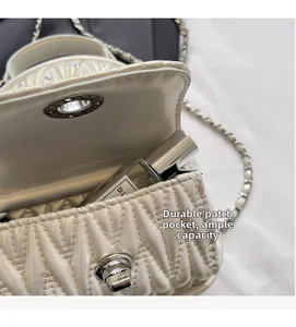 Detailed interior of beige quilted mini crossbody bag showing storage capacity and pocket