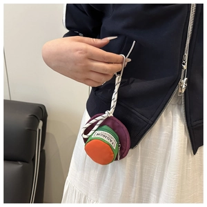 Mini round color-block pouch with metal carabiner clipped on a navy jacket pocket
