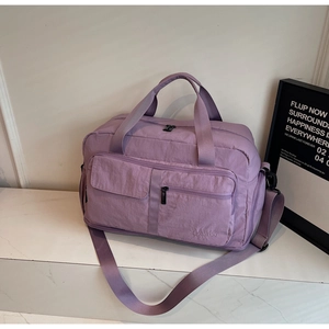 Detailed view of purple large travel bag with dual front zippers and woven handles