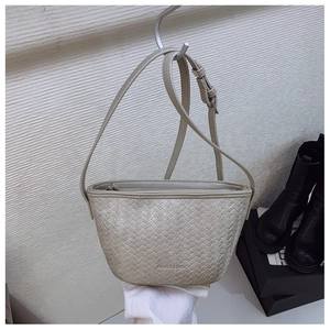 Detail of woven texture on minimalist bucket bag with adjustable shoulder strap