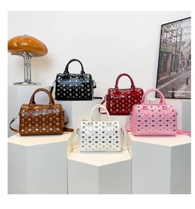 Detailed view of studded Boston bags in five colors on geometric stands with art decor