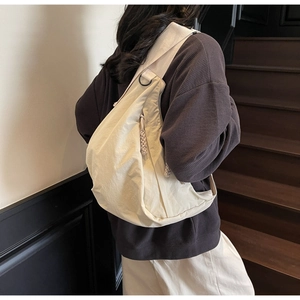 Detail of off-white dumpling bag in durable nylon with adjustable wide shoulder strap
