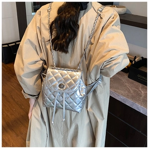 Detail of silver quilted backpack with metal chain strap and twist lock closure