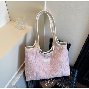 Detail of pink quilted tote bag with rainbow embroidery and brand leather patch