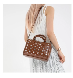 Detail view of brown punk-style Boston bag with metallic silver studs on leather
