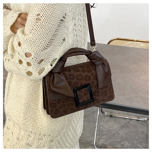 Detail of leopard print crossbody bag with knotted handle and suede texture on dress