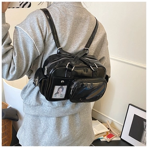 Detail of glossy black multi-zipper backpack with transparent card slot and illustrations