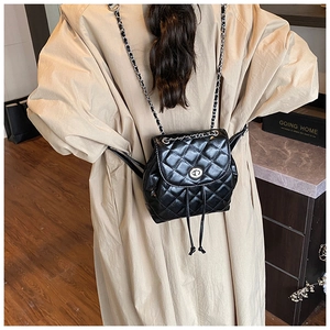 Detail view of black quilted mini backpack with chain strap and metallic twist-lock