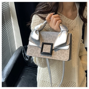 Detailed shot of the silver metal bow handle and leopard print texture on a square bag