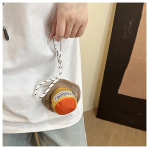 Detailed view of the mini bucket hat coin purse hanging on a model's bag strap