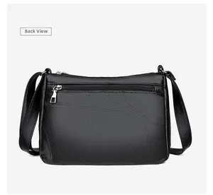 Detailed back view of women's black leather crossbody bag with leaf embossed pattern