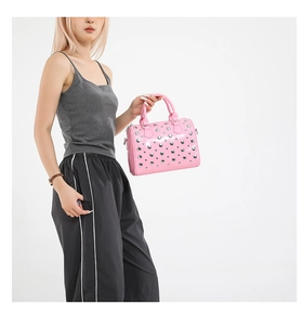 Detail of pink leather Boston bag with silver metal rivets and double handle grips