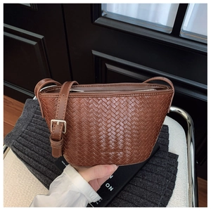 Close-up of brown woven texture and adjustable shoulder strap on a bucket bag