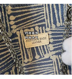 Close-up of woven tote bag with geometric pattern, leather tag and fluffy charm
