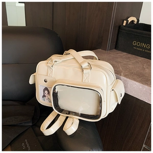 Detailed view of beige ita bag featuring a clear window and glossy leather texture