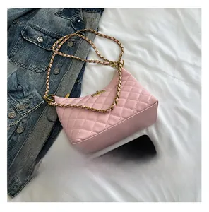 Detailed macro shot of the pink quilted texture and gold chain strap of this shoulder bag