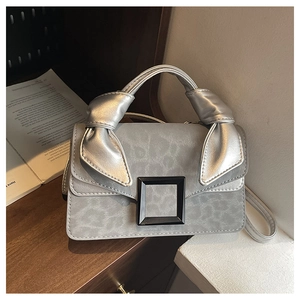 Detailed close-up of grey leopard print handbag with metal clasp and silver knotted handle