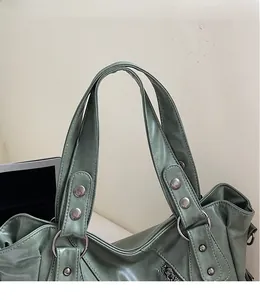 Dettaglio borsa tote in pelle PU verde con rivetti in metallo e doppi manici rinforzati