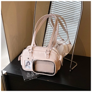 Detailed close-up of pink patent leather shoulder bag with transparent PVC display window