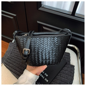 Close-up of black woven bucket bag showing detailed leather texture and silver buckle strap