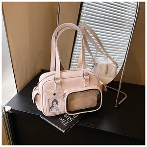 Detail of light pink ita bag with transparent front window and card slot on a desk