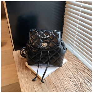 Detail of black quilted leather mini backpack with silver chain handle and twist lock