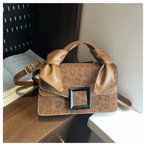 Detailed view of leopard print suede拼接 bag featuring black metal buckle and knotted handle