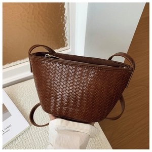 Close-up of deep brown woven texture and silver zipper detail on the bucket bag
