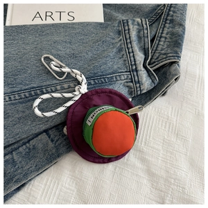 Macro detail of tricolor cap-shaped earphone pouch with zipper and carabiner clip