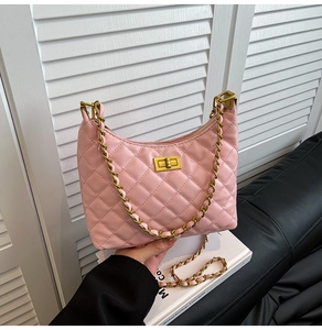 Close-up of pink quilted leather hobo bag with gold chain strap and metal lock detail
