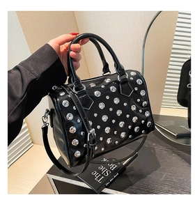 Detail of black faux leather Boston bag with silver punk rivets and sturdy handles