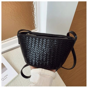 Detailed view of the black woven texture and metal zipper on the bucket shoulder bag