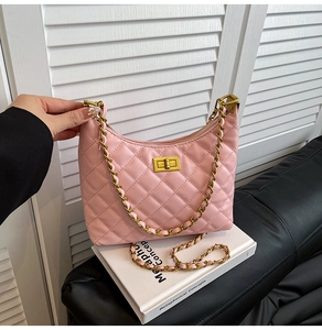 Detailed view of pink quilted leather bag with gold chain strap and twist lock closure