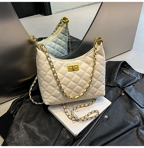 Close-up of beige quilted hobo bag with chain strap and gold twist lock detail
