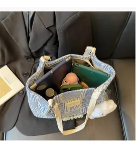 Spacious interior of canvas tote bag showing pearl chain and ample storage capacity
