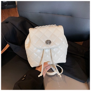 Detailed view of white quilted backpack with silver twist-lock and chain handle