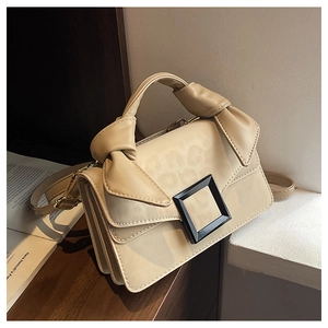 Detail of beige handbag featuring a bow handle and square buckle with leopard print