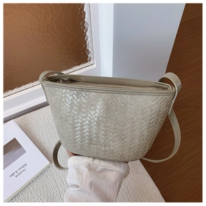Detail of woven texture and brand logo on light grey minimalist bucket bag