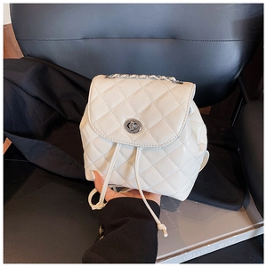 Close-up of white quilted mini backpack with silver chain handle and twist-lock closure
