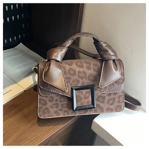 Close-up of leopard print handbag featuring artistic knotted handle and black buckle