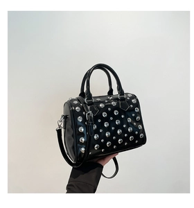Detail view of the silver studs and glossy black leather on the Boston bag