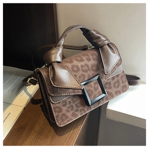 Detail view of leopard print crossbody bag featuring vintage square buckle and suede texture