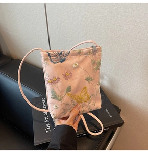 Detail view of pink crossbody bag with exquisite floral and butterfly embroidery