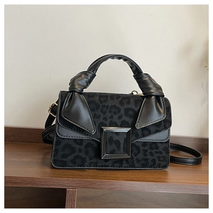 Detail shot of the black leopard print fabric and square metal buckle on a shoulder bag