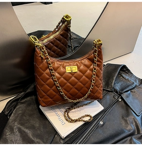 Detail of brown quilted leather bag with gold chain strap and metallic twist lock clasp